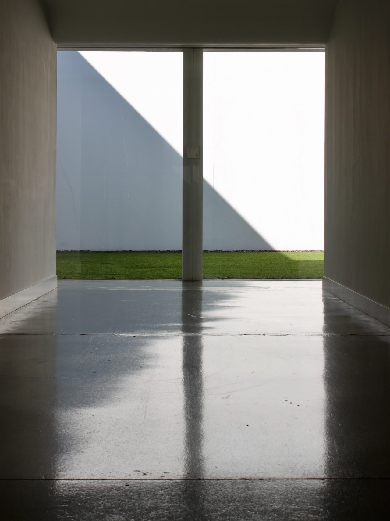 white concrete building with green grass field