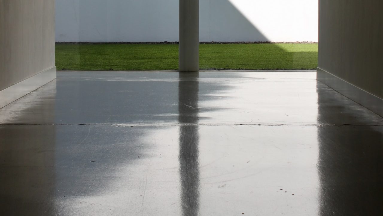 white concrete building with green grass field